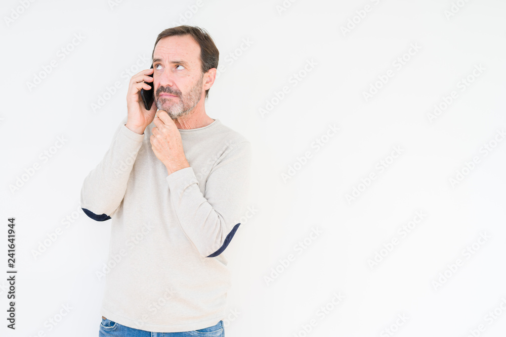 Senior man talking on smartphone over isolated background serious face thinking about question, very confused idea