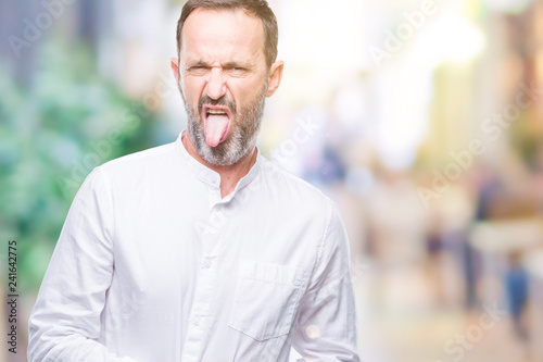 Middle age hoary senior man over isolated background sticking tongue out happy with funny expression. Emotion concept.