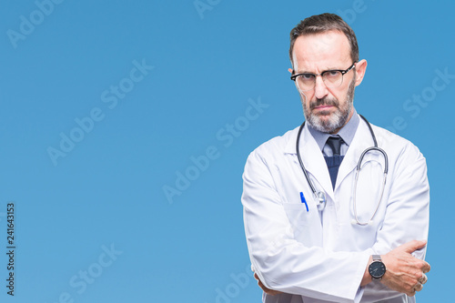 Foto Middle age senior hoary doctor man wearing medical uniform isolated background skeptic and nervous, disapproving expression on face with crossed arms