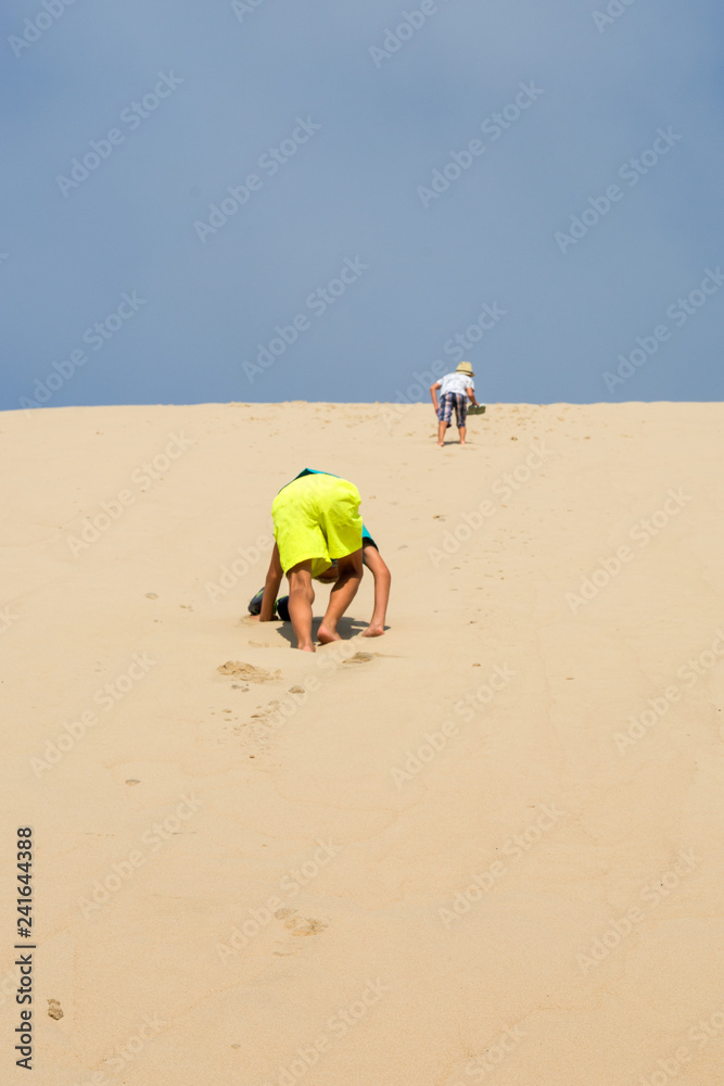 Obraz premium young boys running on the sand dune