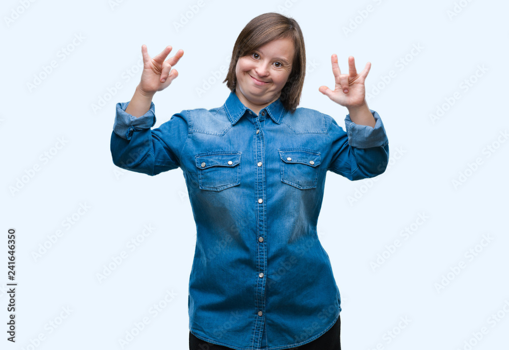 Young adult woman with down syndrome over isolated background shouting with crazy expression doing rock symbol with hands up. Music star. Heavy concept. Young adult woman with down syndrome over isolated background shouting with crazy expression doing rock symbol with hands up. Music star. Heavy concept.