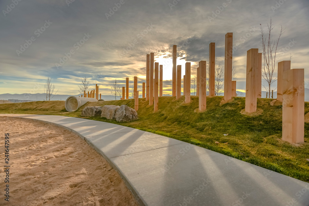 A sunset behind wooden pillars and playground