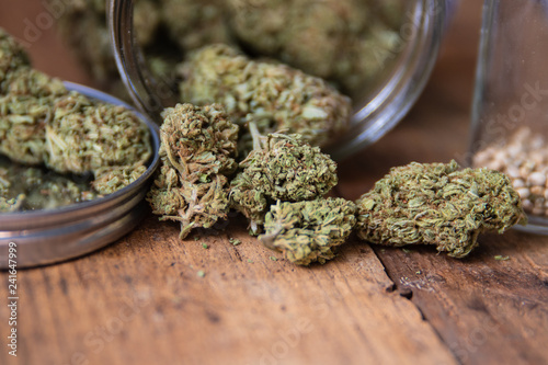 Marijuana Bud Flowers In Glass Jar Up Close On Natural Wood