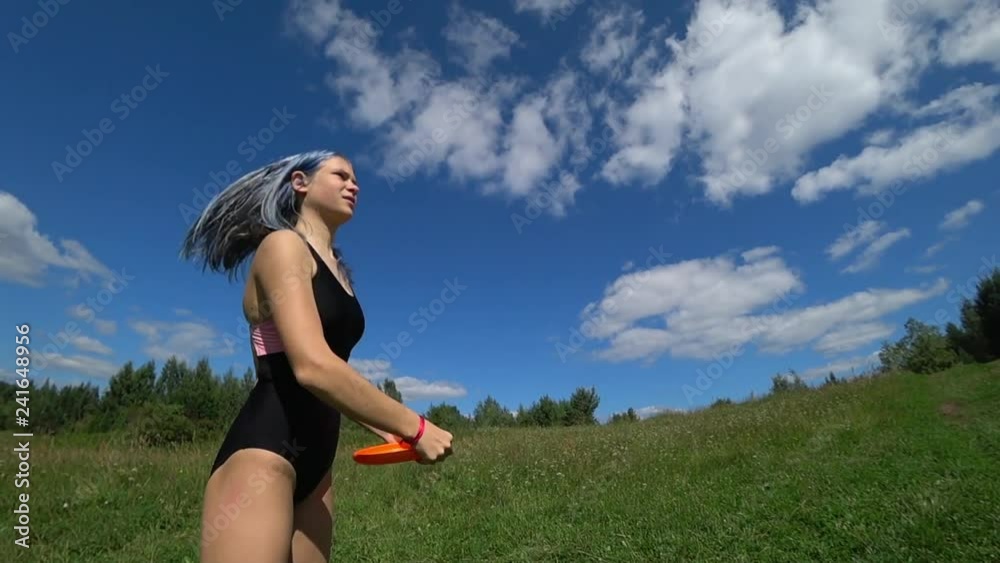 Cute girl playing frisbee ouside in the park in summer in slow motion Cute girl playing frisbee ouside in the park in summer in slow motion