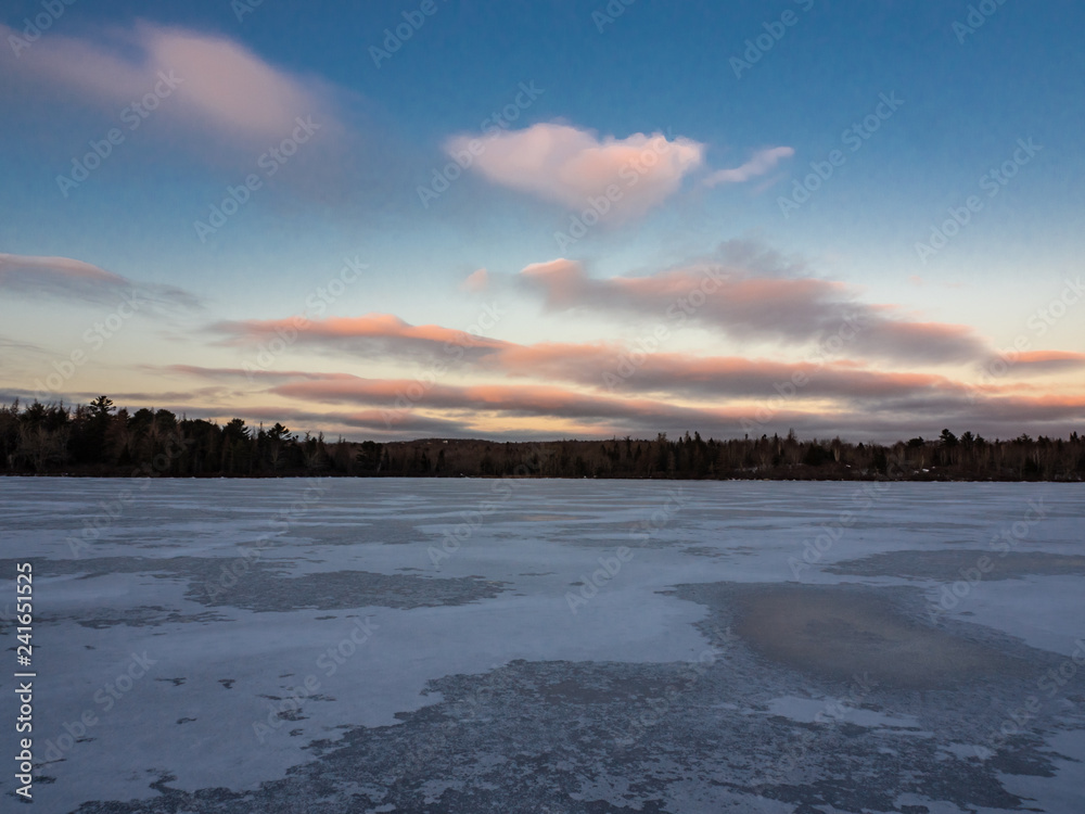 sunset over a frozen lake in winter