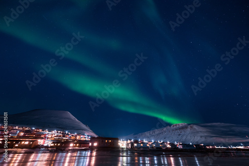 The polar arctic Northern lights aurora borealis sky star in Norway Svalbard in Longyearbyen the moon mountains photo