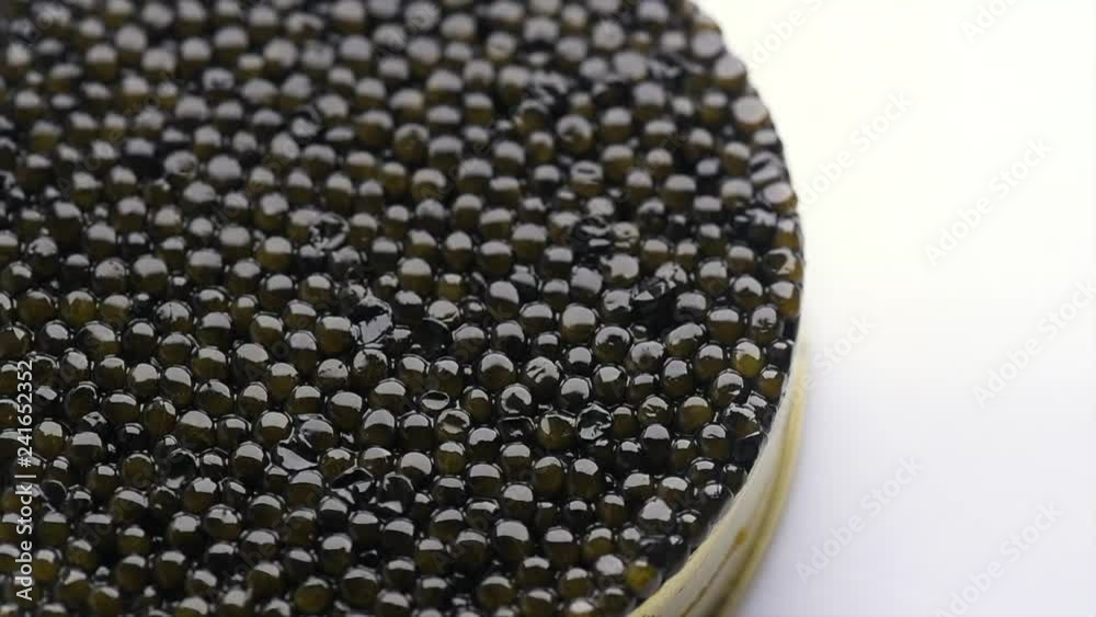 Caviar closeup. Black caviar rotated on white background. High quality natural sturgeon caviar close-up, rotation. Delicatessen. 4K UHD video footage 3840X2160 Caviar closeup. Black caviar rotated on white background. High quality natural sturgeon caviar close-up, rotation. Delicatessen. 4K UHD video footage 3840X2160