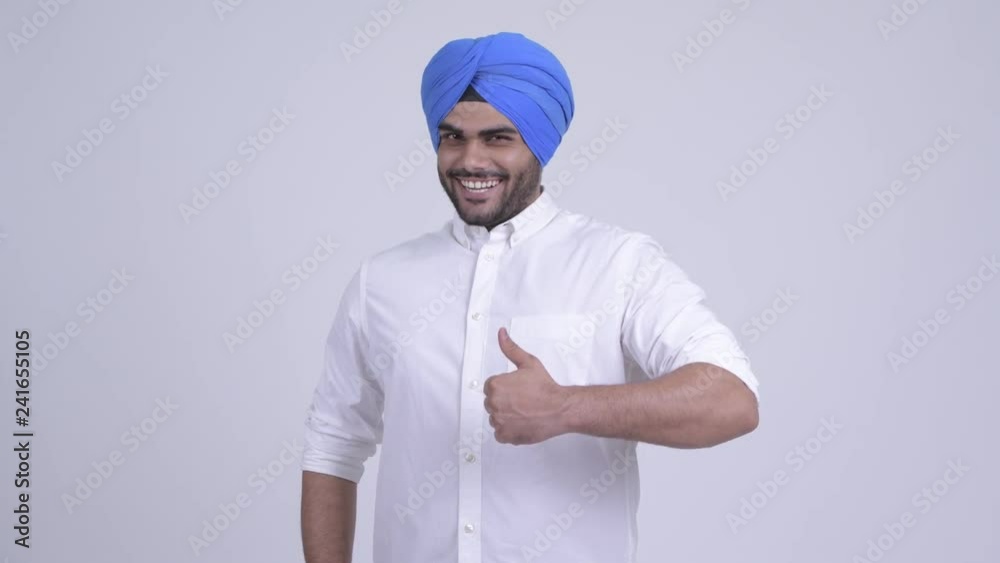 Happy young bearded Indian Sikh man giving thumbs up Happy young bearded Indian Sikh man giving thumbs up