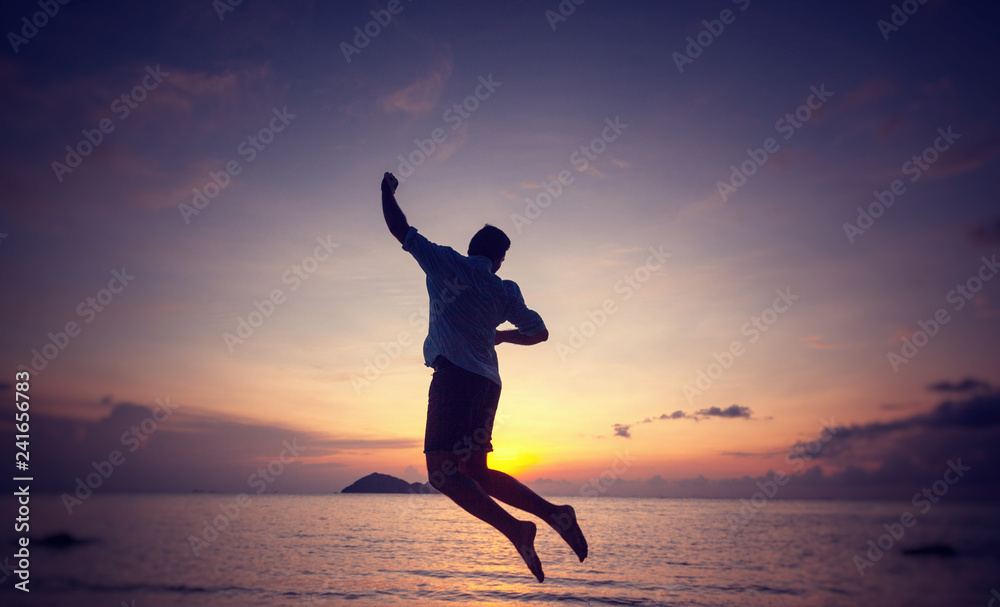 Silhouette of a jumping man on the seashore at sunset, man and nature concept, beauty lifestyle freedom vacation travel