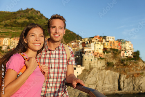 Romantic couple in love by sunset on holidays travel. Young beautiful couple enjoying ocean view romance. Young people, man and woman traveling on vacation in Manarola, Cinque Terre, Liguria, Italy
