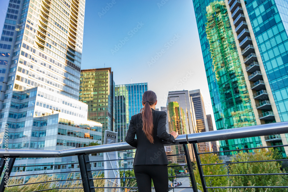 Naklejka premium Biznes kobieta w centrum miasta, patrząc na widok na panoramę wieżowców w centrum Vancouver, Kanada. Bizneswoman od tyłu zamyślona myśląca o sukcesie i przyszłości w karierze i pracy.