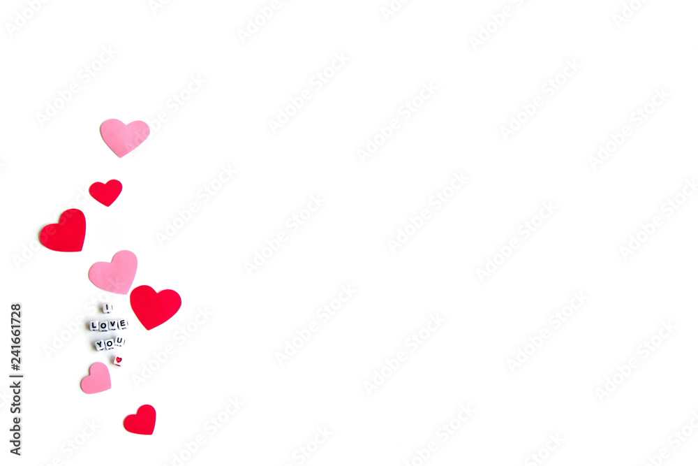 .Phrase I Love You constructed from white letter cubes, Pink and Red Hearts on a White Background. Romance Valentine Mother's Day concept.