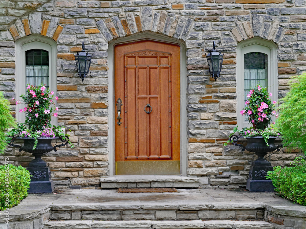 Naklejka premium elegant wooden front door of stone house