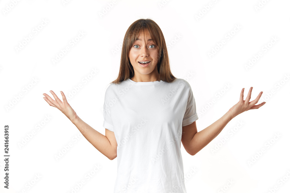 Unsure or doubting caucasian woman in white t-shirt throws up her arms in perplexity, without knowing how she managed to lose weight so quickly, isolated over white background Unsure or doubting caucasian woman in white t-shirt throws up her arms in perplexity, without knowing how she managed to lose weight so quickly, isolated over white background