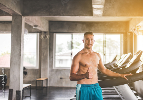 Fit man standing and thumb up relax after the training session in gym,Concept healthy and lifestyle,Male taking a break after exercise and workout