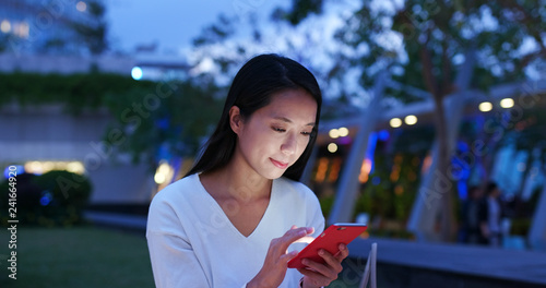 Canvas Print Woman use of mobile phone in city at night