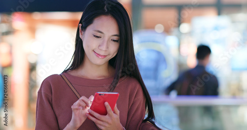Εκτύπωση καμβά Woman check on the discount in mobile phone inside shopping mall