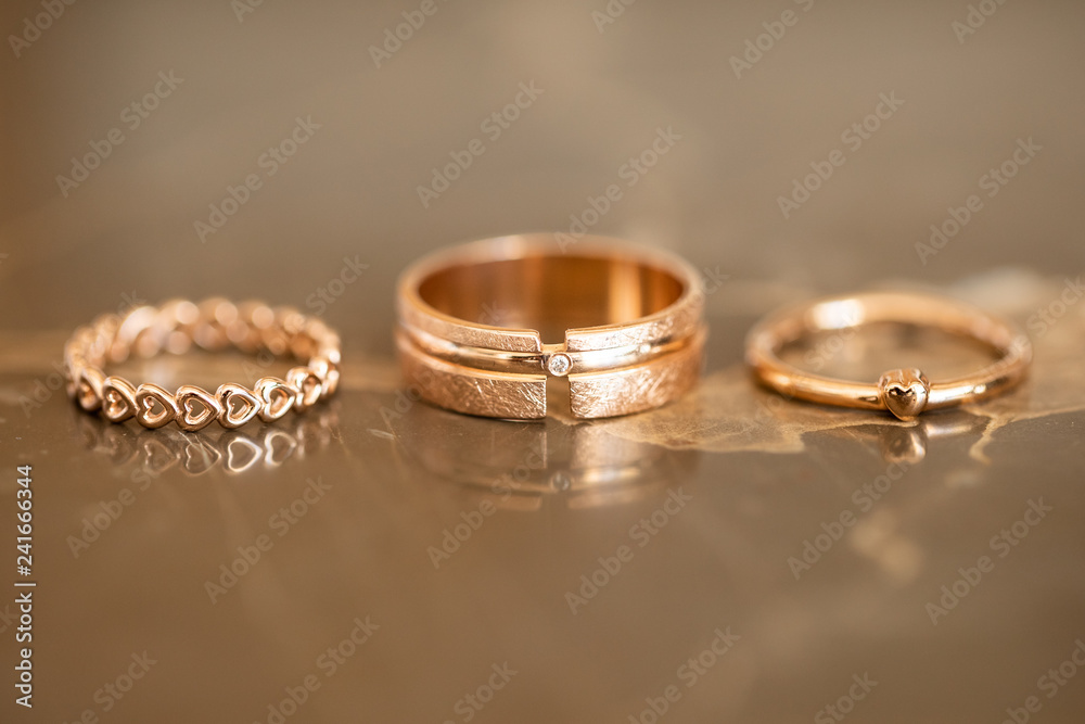 Forever together wedding heart rings on gold marble table, symbolize love and staying forever together, macro Forever together wedding heart rings on gold marble table, symbolize love and staying forever together, macro