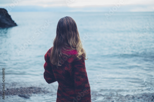 Young woman on the beach looking at the sea