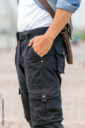 male tourist wearing cargo pants standing in the park.