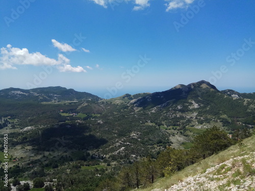 Mountain peaks and clouds in the sky. Montenegro Sunny summer day, windless weather.