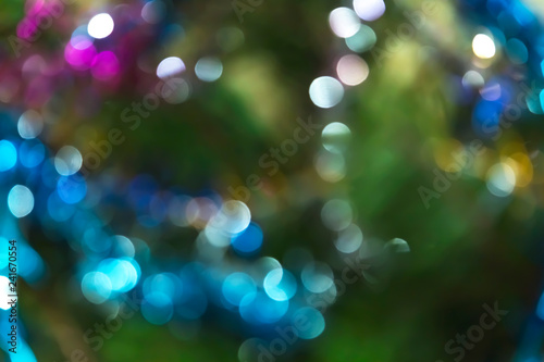 Abstract festive New Year Christmas defocused background with bokeh multicolored effect on a green background with copy space.