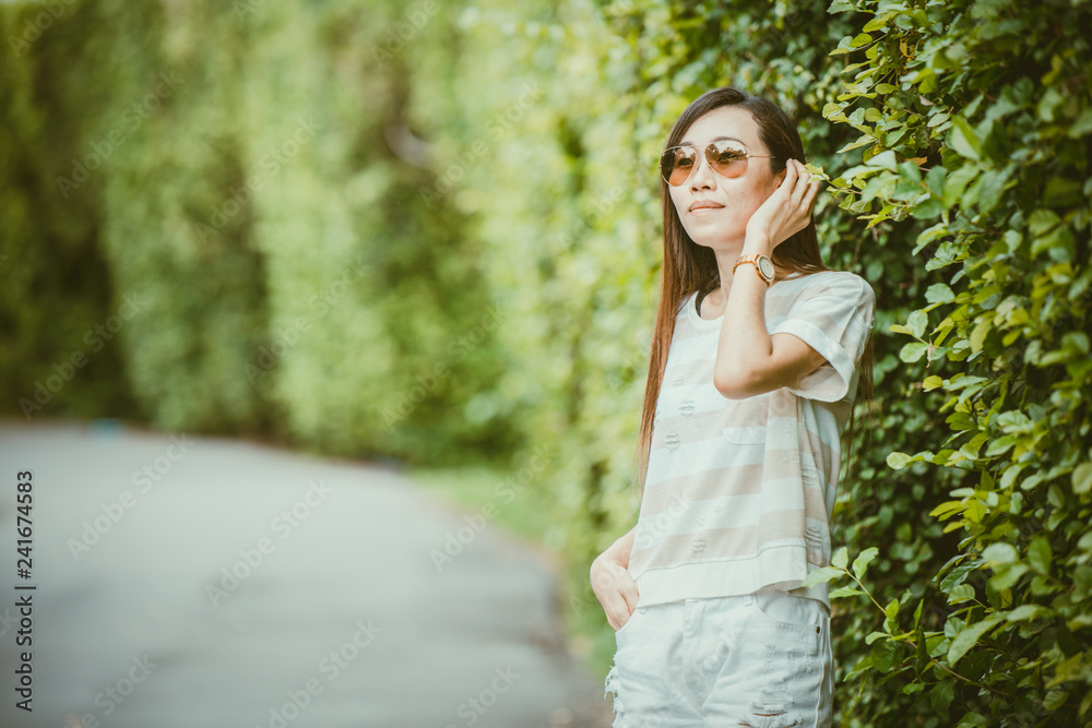 asian thin hipster girl wearing sunglasses in the green park relax holiday vintage color tone asian thin hipster girl wearing sunglasses in the green park relax holiday vintage color tone