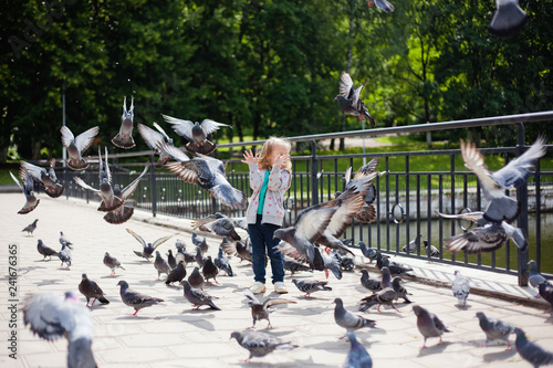 girl in the Park playing and feeding pigeons © Elena 
