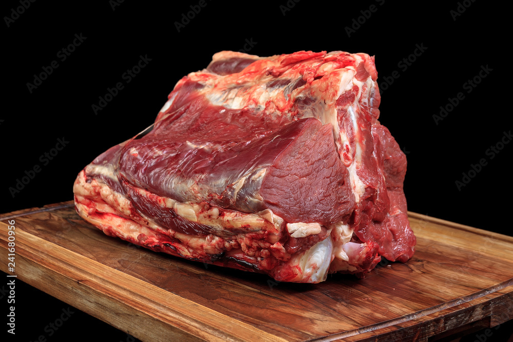 fresh raw red beef meat big steak chunk on wooden cut board isolated over black background