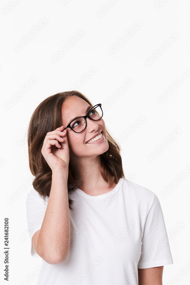 Smiling girl in glasses looking uyp, studio