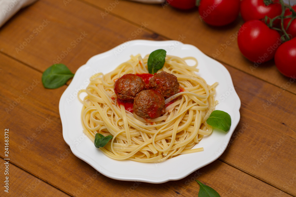 Spaghetti pasta meatballs with tomato sauce, basil, herbs Parmesan cheese on wooden background. Selective focus Spaghetti pasta meatballs with tomato sauce, basil, herbs Parmesan cheese on wooden background. Selective focus