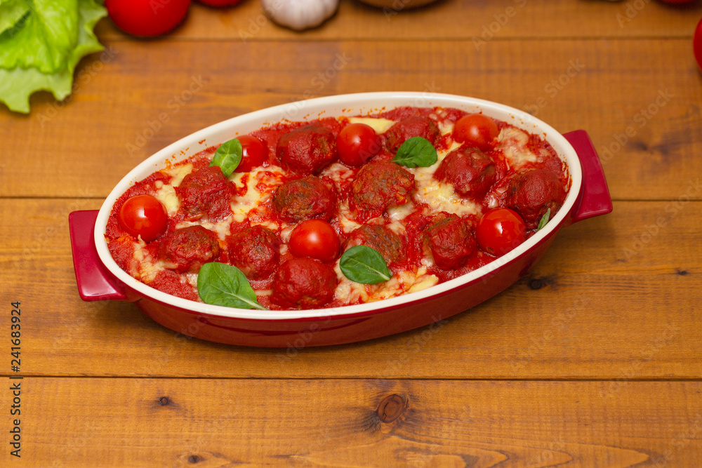 Meatballs in tomato sauce in a baking dish on a wooden table. Selective focus Meatballs in tomato sauce in a baking dish on a wooden table. Selective focus