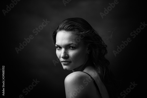 Dramatic black and white portrait of a beautiful girl on a dark background © Restyler