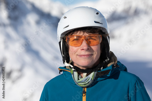 Senior Skifahrerin mit Helm und Brille auf der Skipiste © SundGo