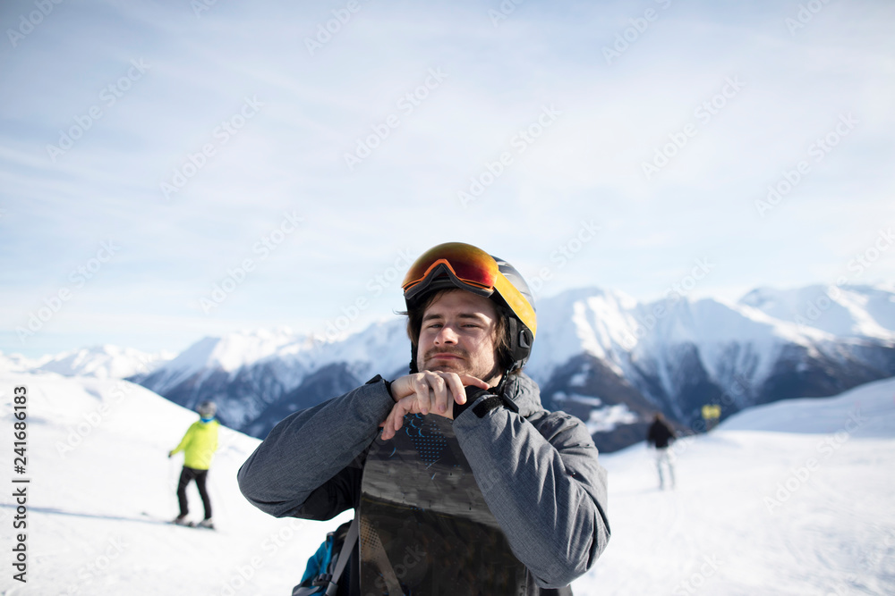 Junger Mann mit Snowboard Skihelm und Skibrille
