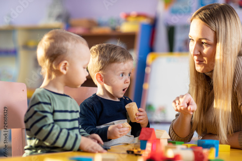 Child building blocks with a teacher in the nursery