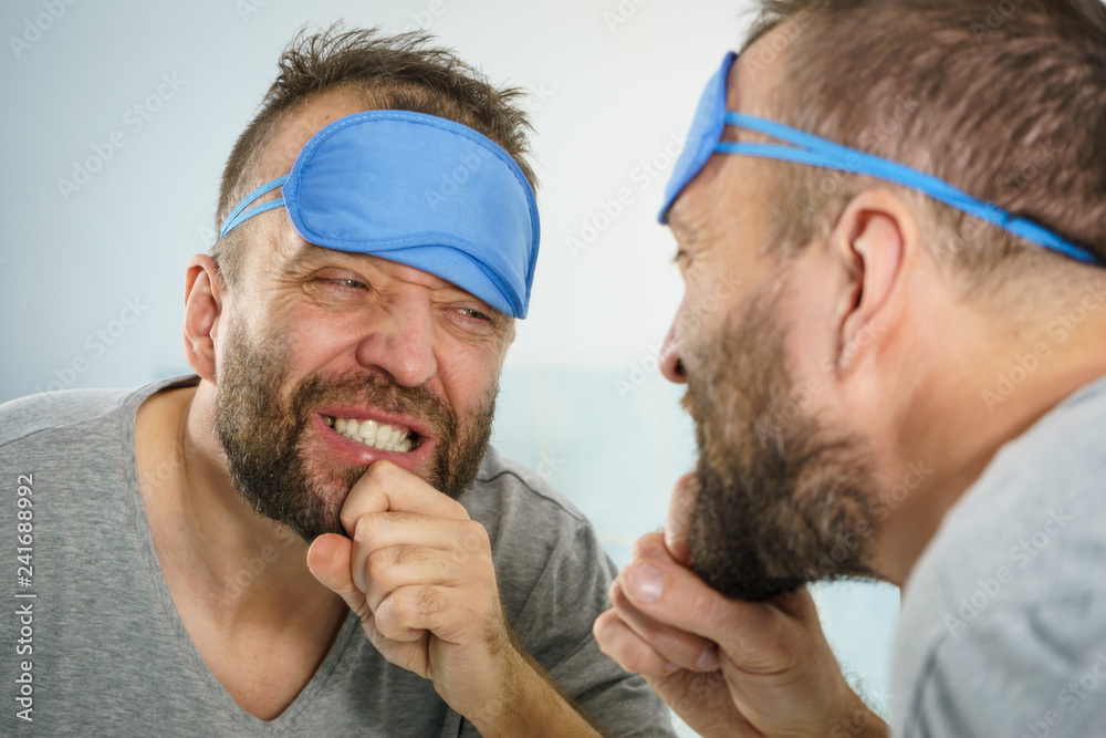 Fototapeta premium Happy man after sleep looking at mirror