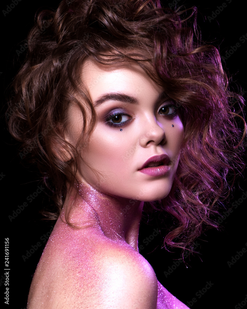 Close up of a gorgeous sexy woman with creative fashion make up: glitters and glamour shine. Curly evening hairstyle. Sexy look