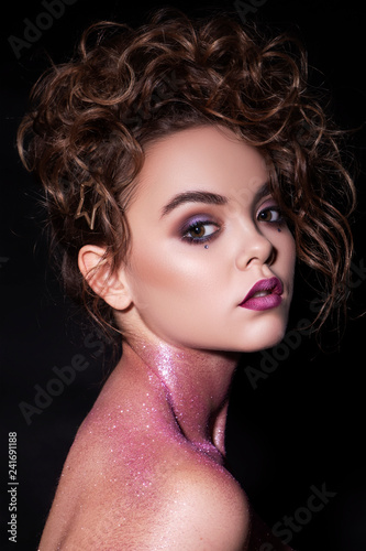 Close up of a gorgeous sexy woman with creative fashion make up: glitters and glamour shine. Curly evening hairstyle. Sexy look