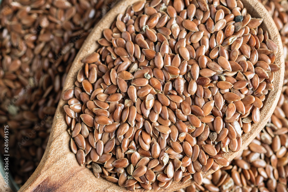 flax seeds in a wooden spoon on an old table flax seeds in a wooden spoon on an old table