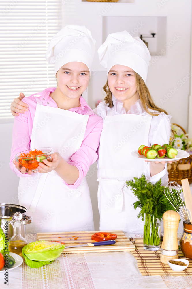 Close-up portrait of two cute girls cooking Close-up portrait of two cute girls cooking