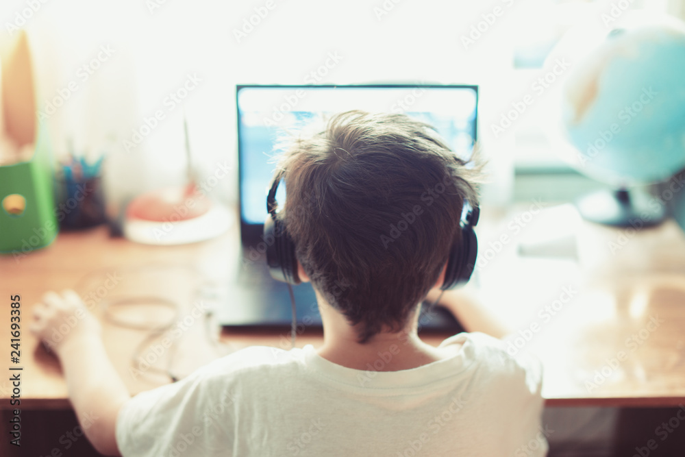 Talented gamer left handed boy playing on laptop Talented gamer left handed boy playing on laptop