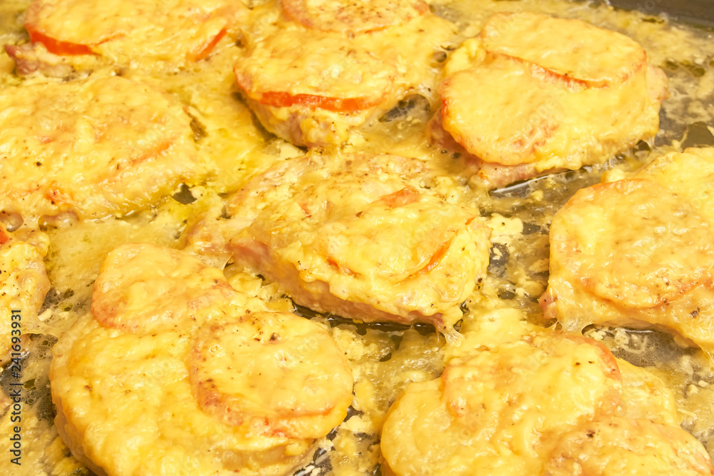 Baked meat with tomatoes and cheese, background texture close up Baked meat with tomatoes and cheese, background texture close up