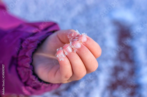 White snow melts in the child's hand
