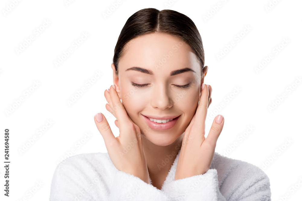 attractive smiling woman in bathrobe with eyes closed touching face isolated on white attractive smiling woman in bathrobe with eyes closed touching face isolated on white