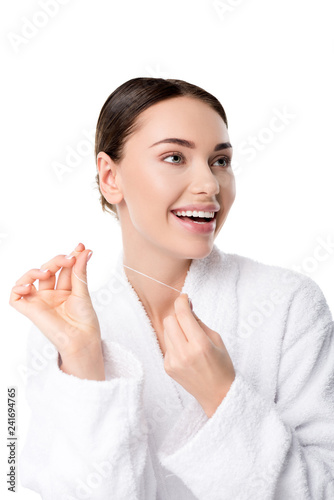 cheerful woman in white bathrobe with dental floss isolated on white