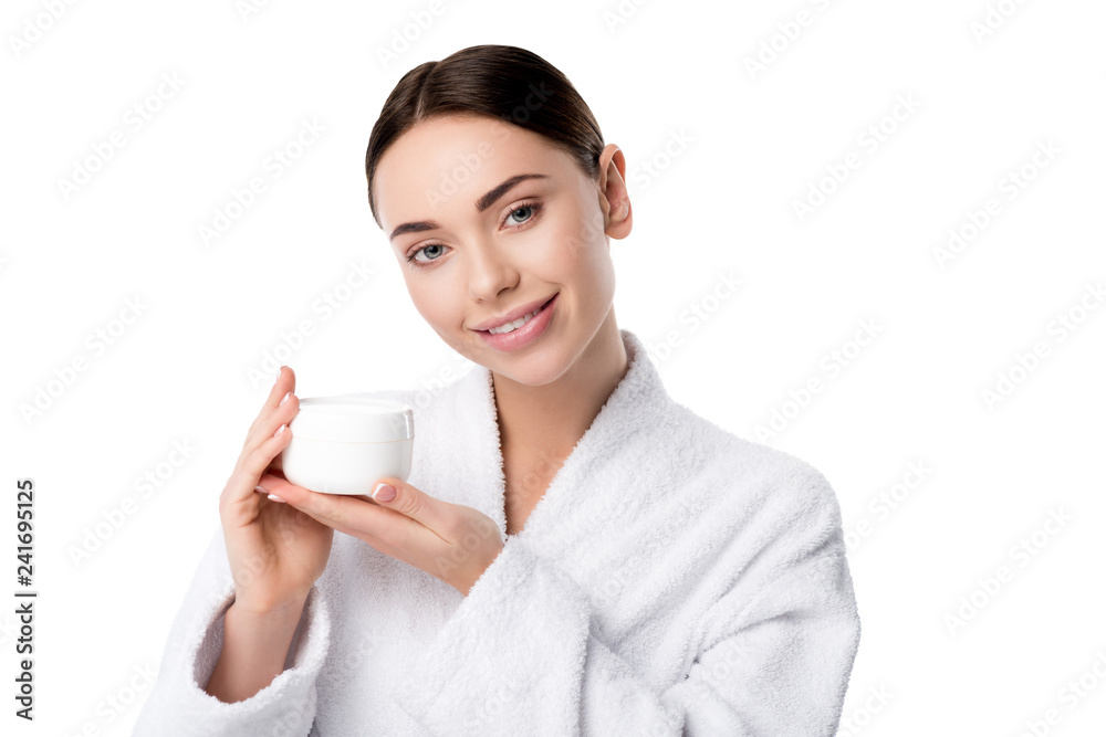 beautiful woman in bathrobe holding face cream and looking at camera isolated on white beautiful woman in bathrobe holding face cream and looking at camera isolated on white