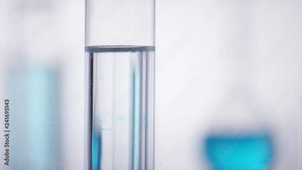 Blue chemical drops into a clean test tube Blue chemical drops into a clean test tube
