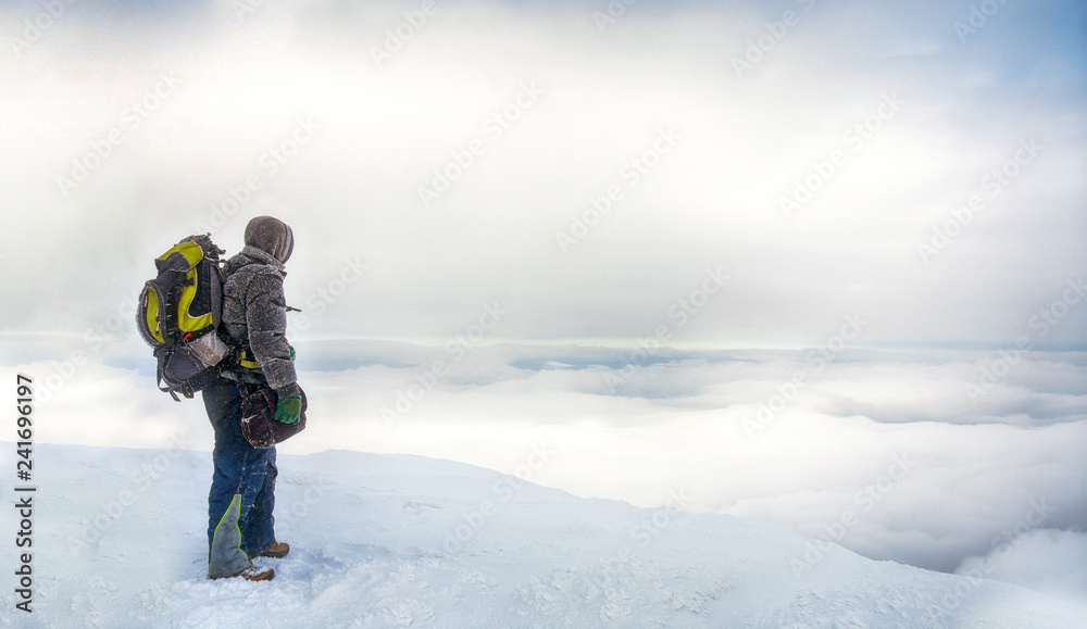 Hiker in a winter mountains. Concept of healthy lifestyle and successful climb,  hiking in nature. Winter background