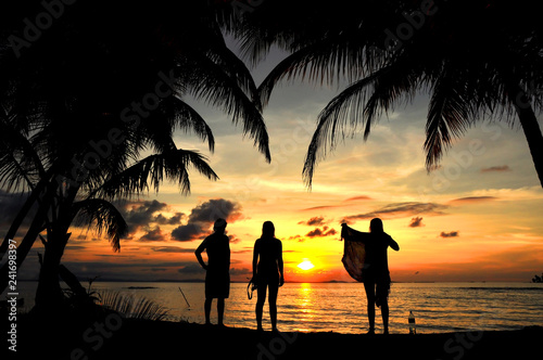 Siluetas de amigos en contraluz divirtiéndose en la puesta de sol. photo